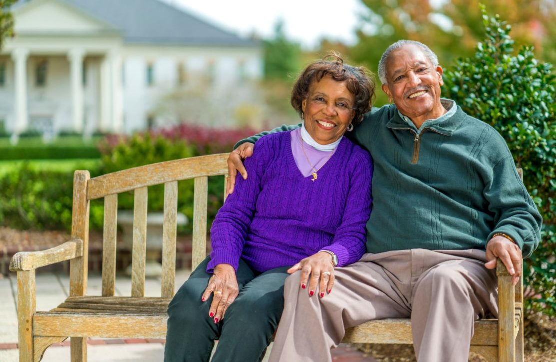 Senior couple enjoying their time on a bench at The Cedars of Chapel Hill, reflecting the lifestyle offered by Life Plan Communities.