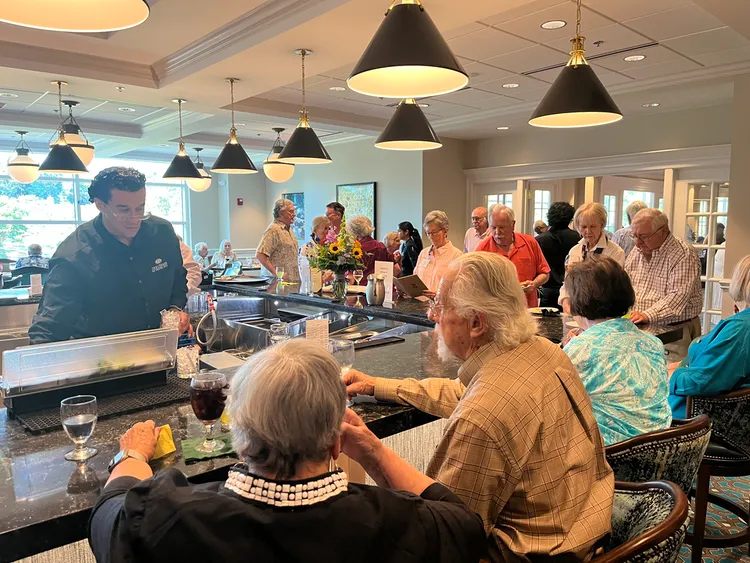 Members gathered at The Cedars Pub during the clubhouse reopening celebration, enjoying drinks and conversation.